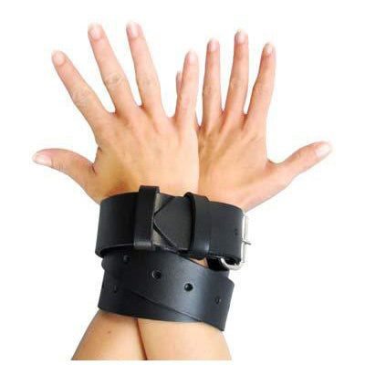 Black leather bondage strap in use as wrist restraints