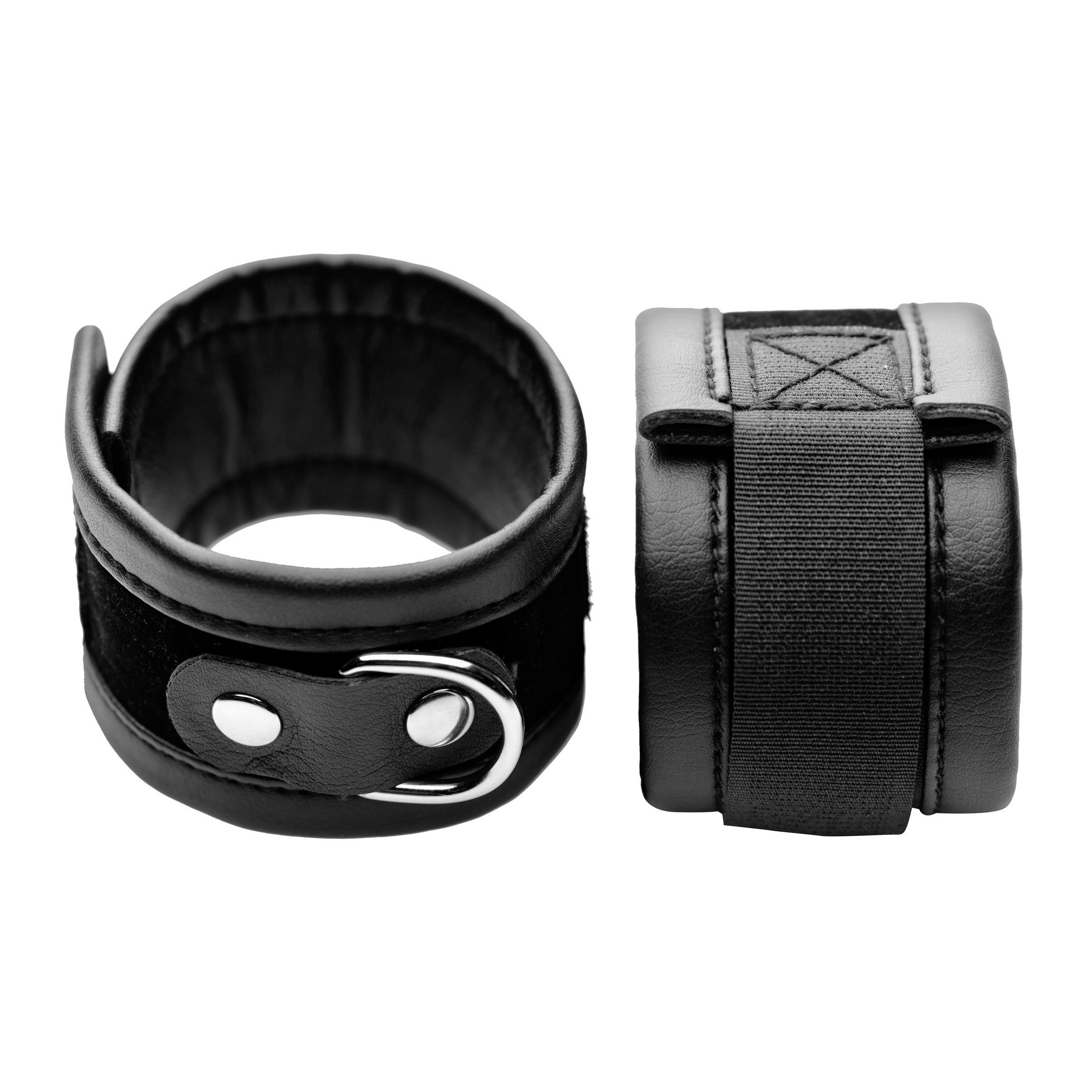 Black leather wrist cuffs with a connecting metal ring from the Bondage Kit