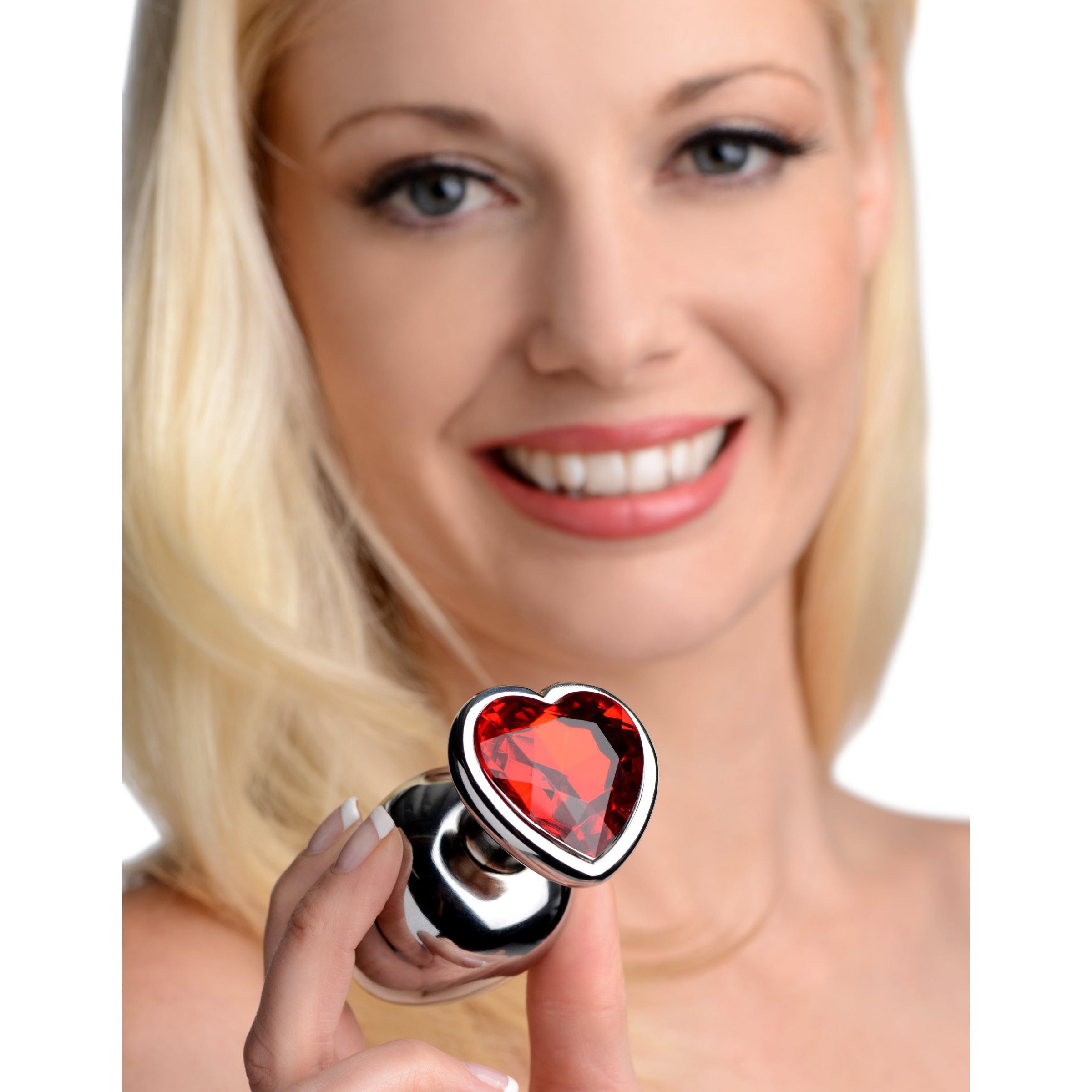 Person holding a Chrome Hearts anal plug with a heart-shaped gem