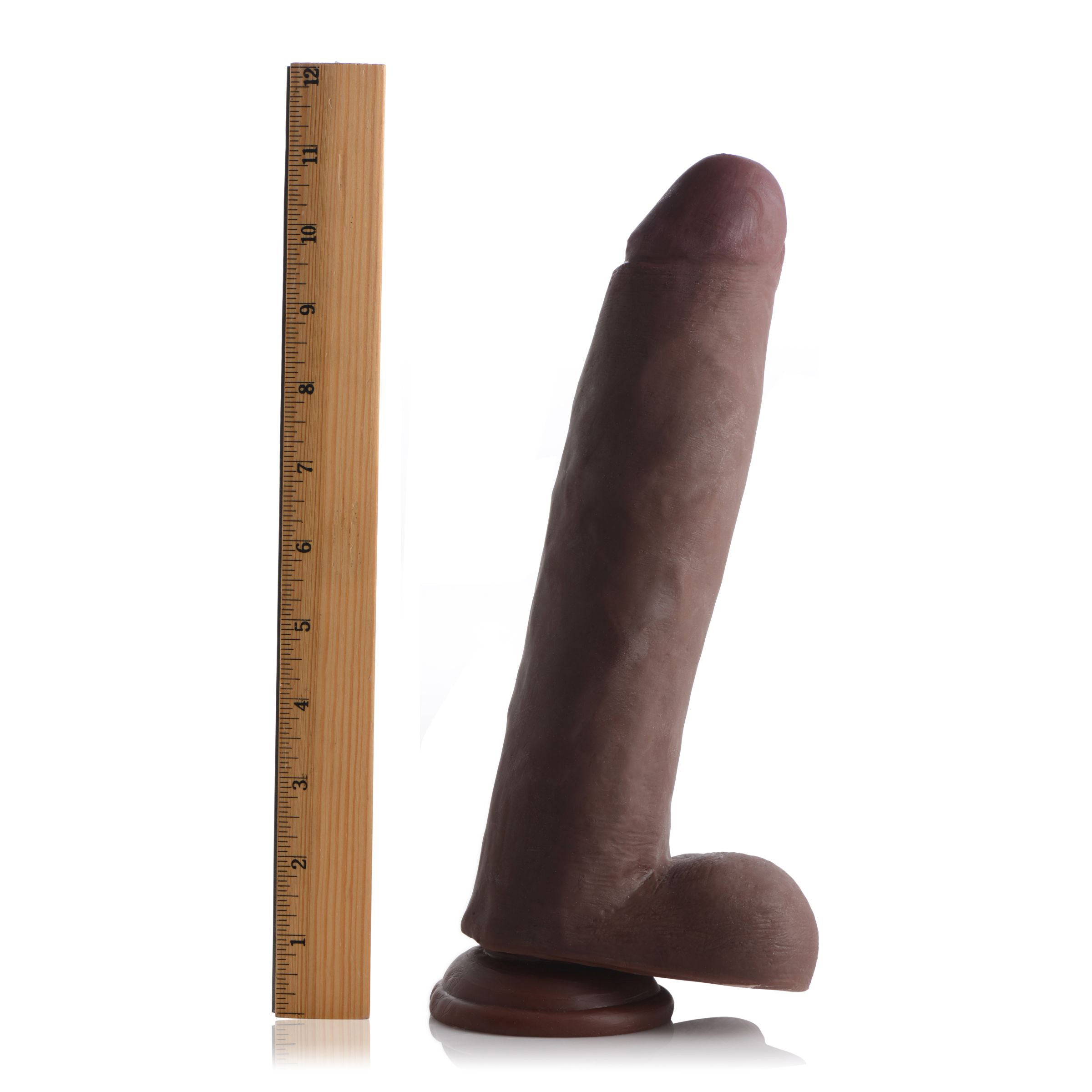 Skintech's realistic 11-inch dildo in a chocolate hue shown with a measuring ruler for scale