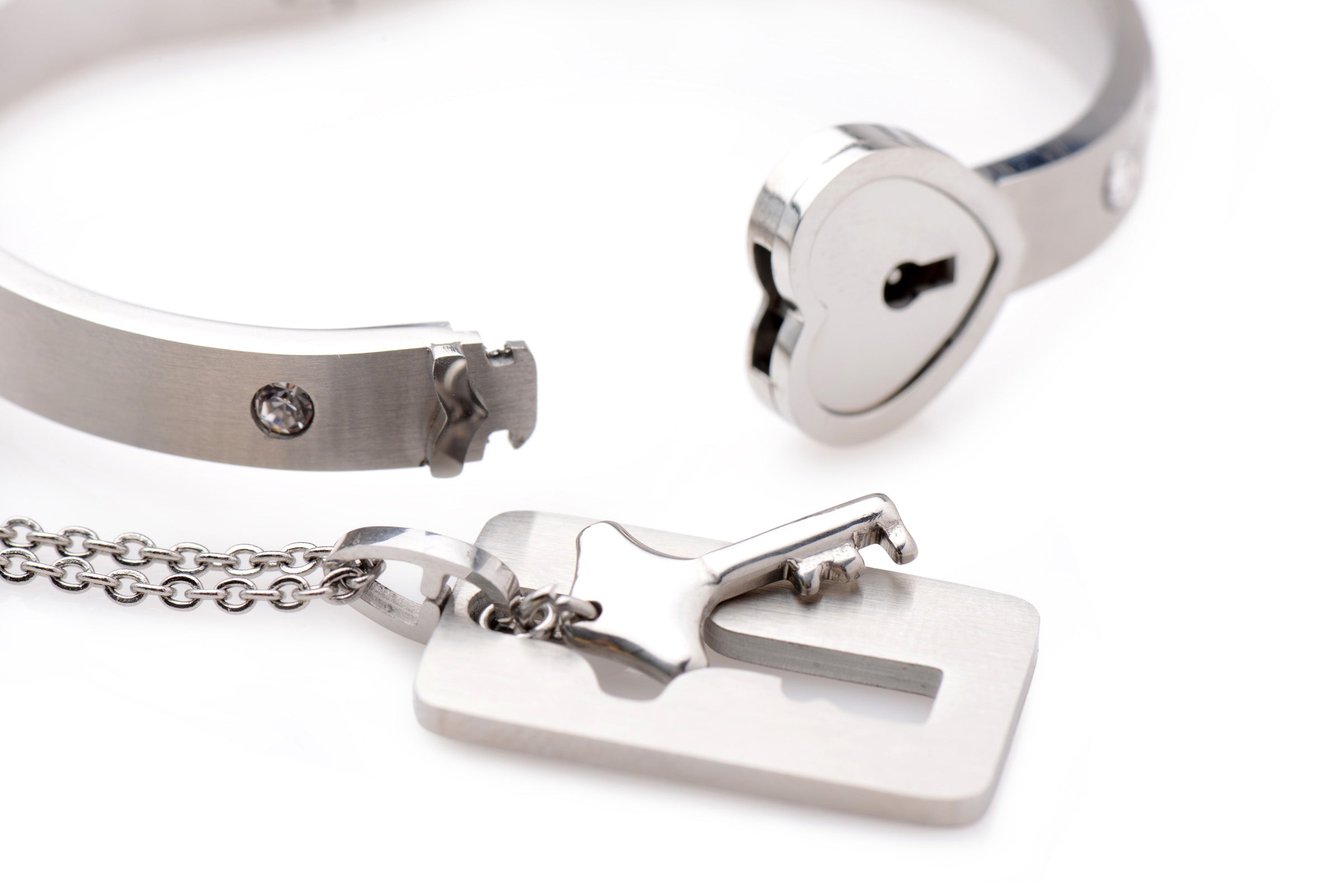 Detailed view of a silver locking bracelet with an attached key and heart lock