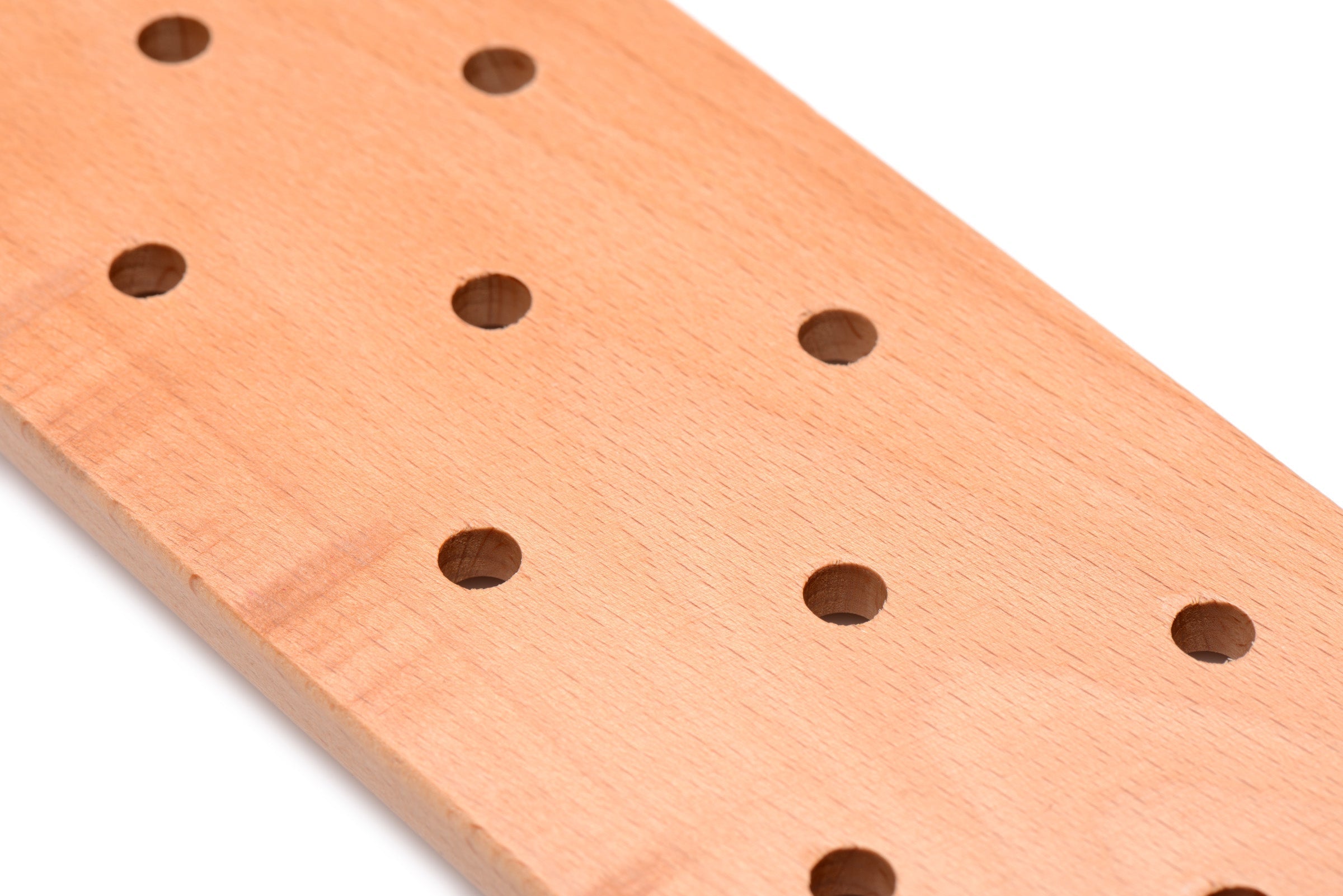 Detail of a wooden paddle showcasing the hole pattern