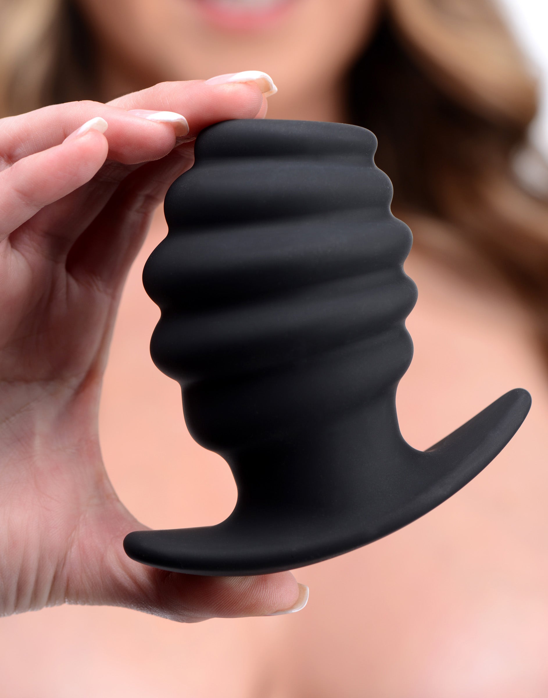 Person holding the Hive Ass Tunnel ribbed silicone anal plug