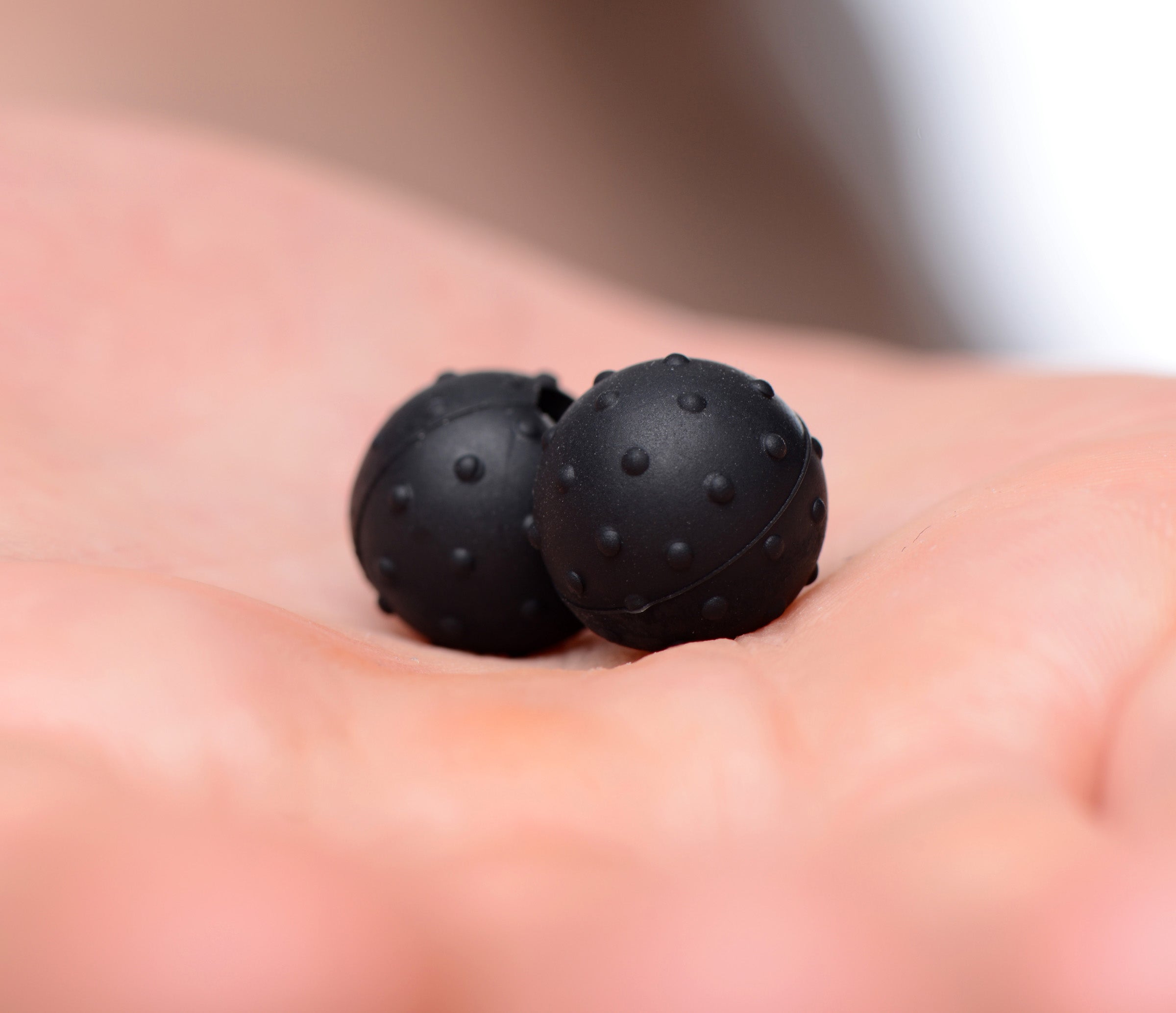 Person holding a pair of Dragon's Orbs Nubbed Silicone Magnetic Balls