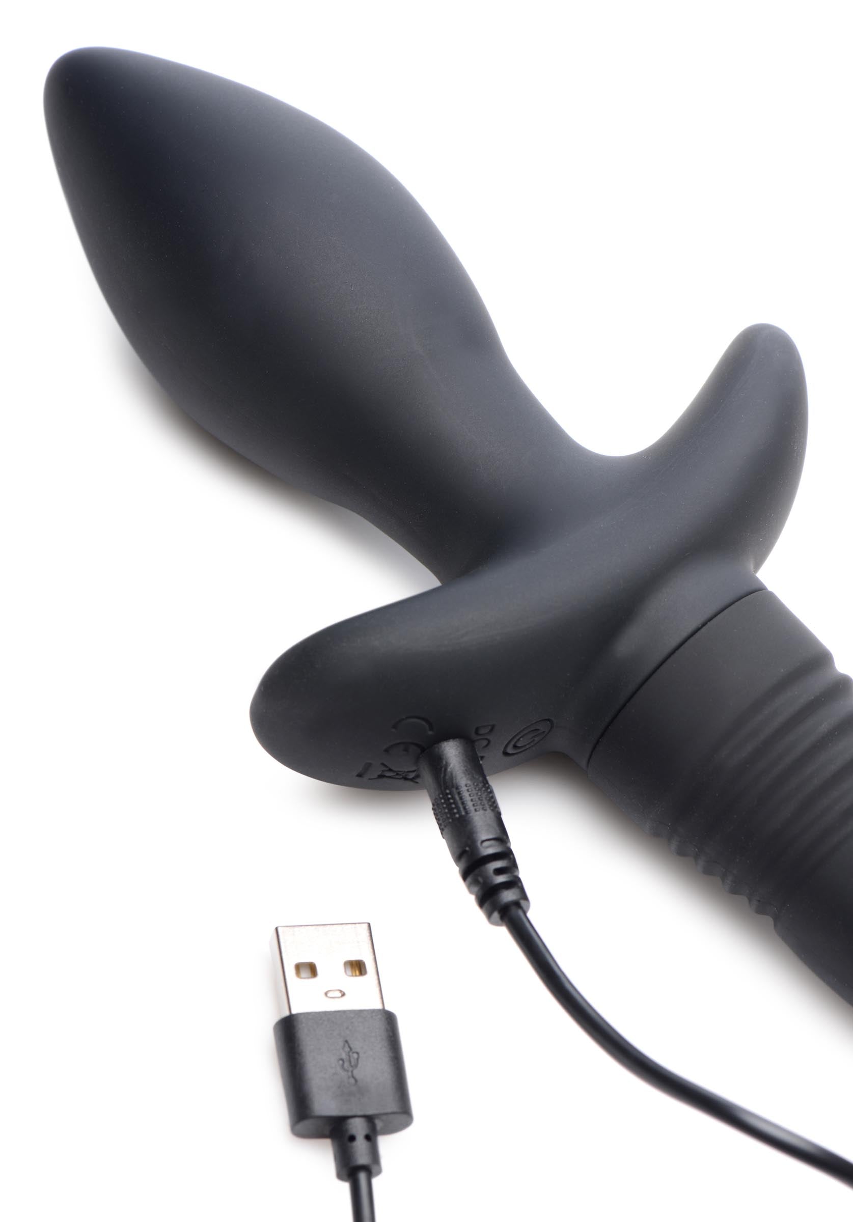 A black anal plug with a wagging puppy tail and a USB cable for charging