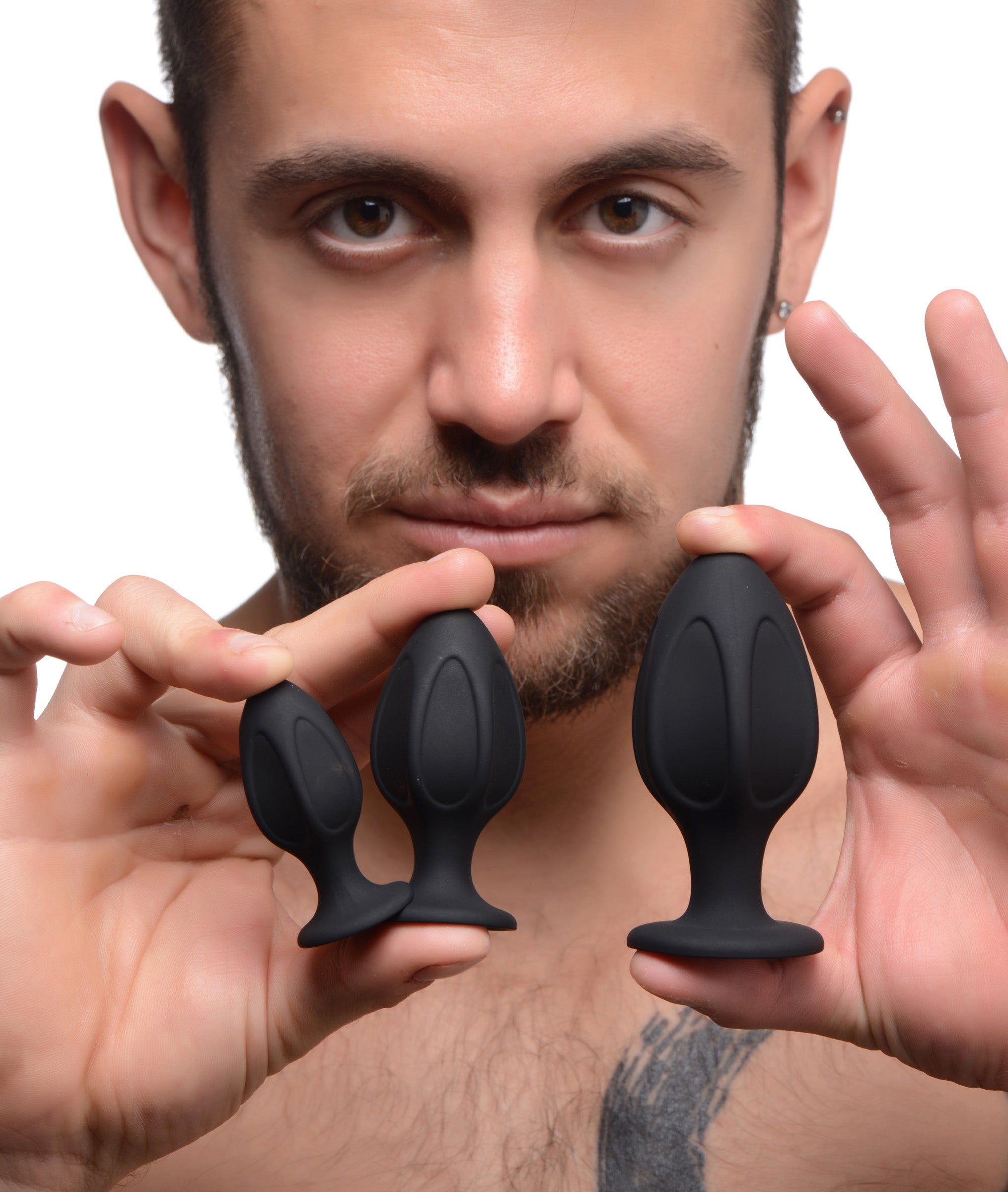 Person holding a pair of silicone anal trainers from the Triple Juicers set