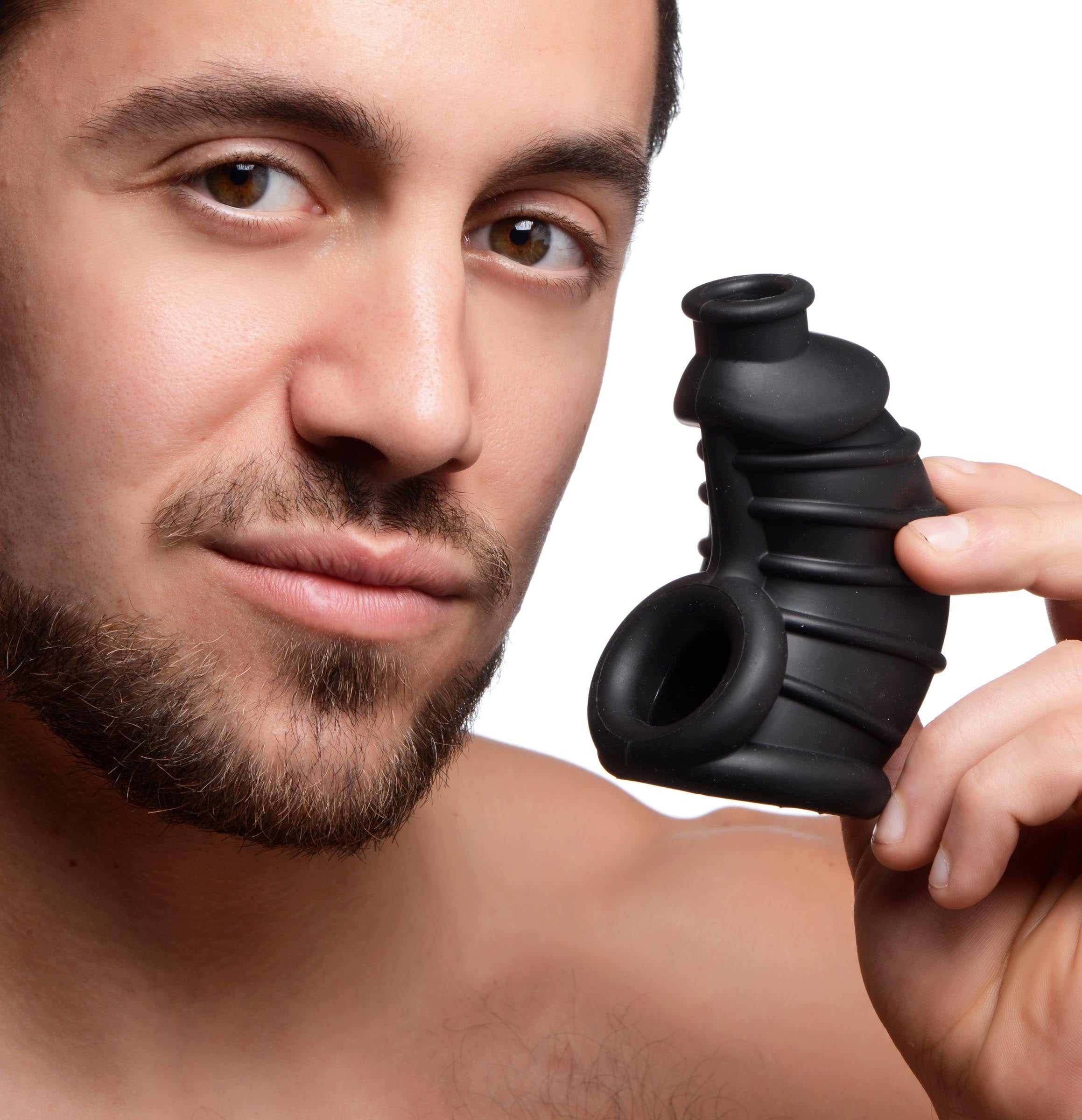 Person holding a silicone male chastity cage in their hand