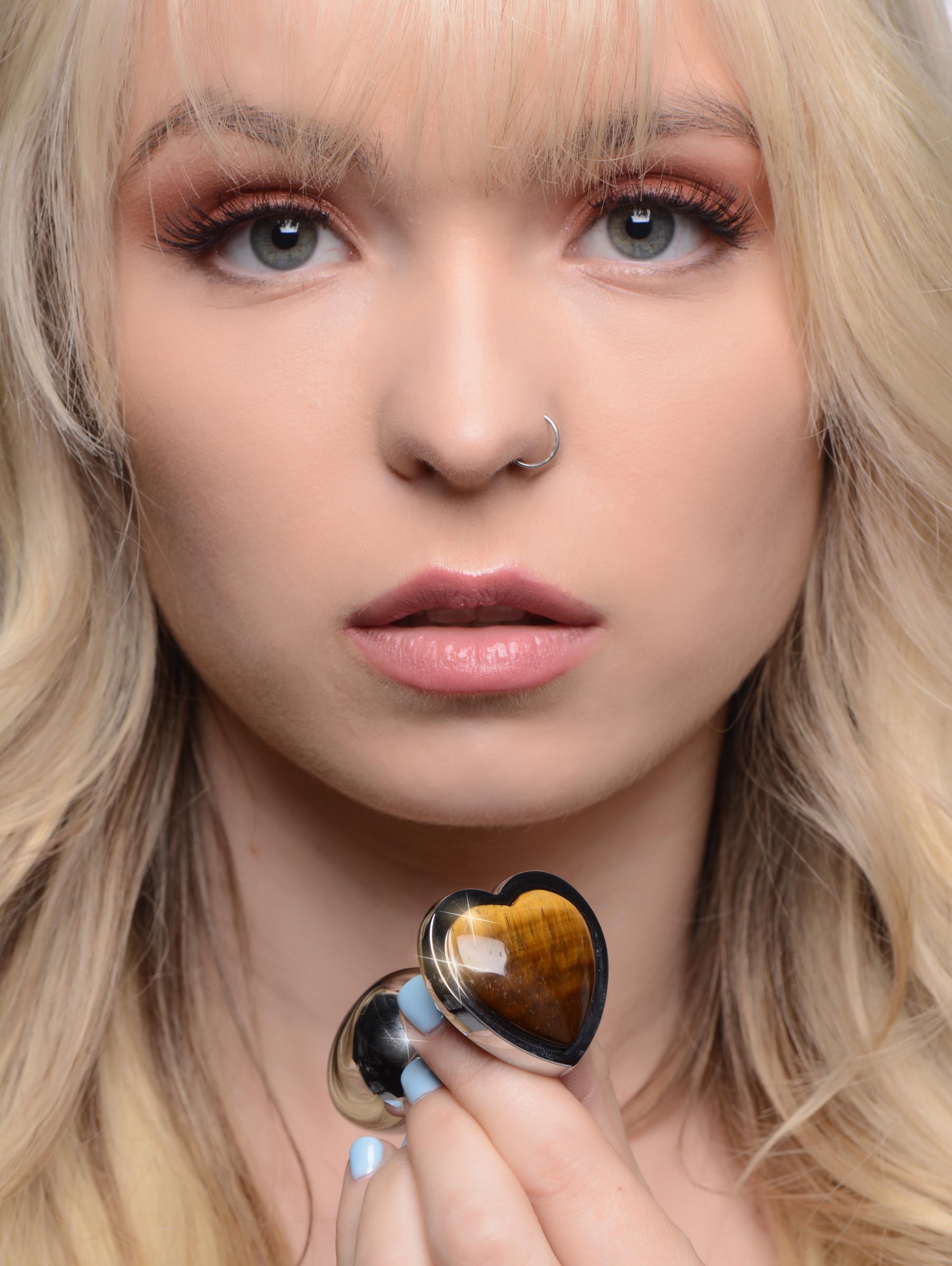 Person displaying the heart-shaped Tigers Eye anal plug in their palm