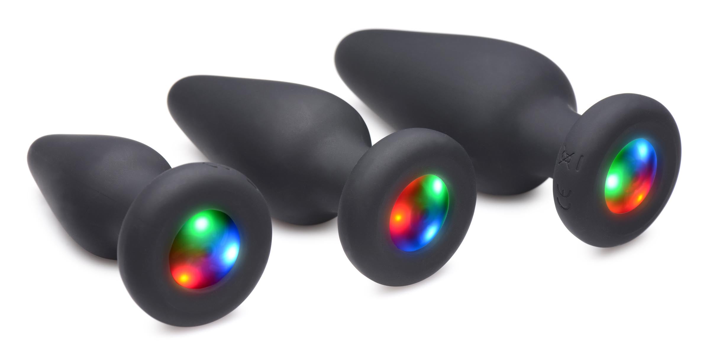 A set of three silicone anal plugs with illuminated multicolor lights