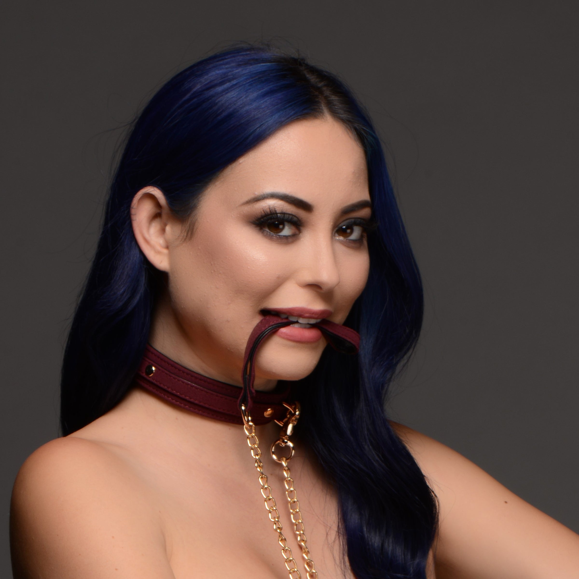 Female model with blue hair wearing a burgundy velvet choker