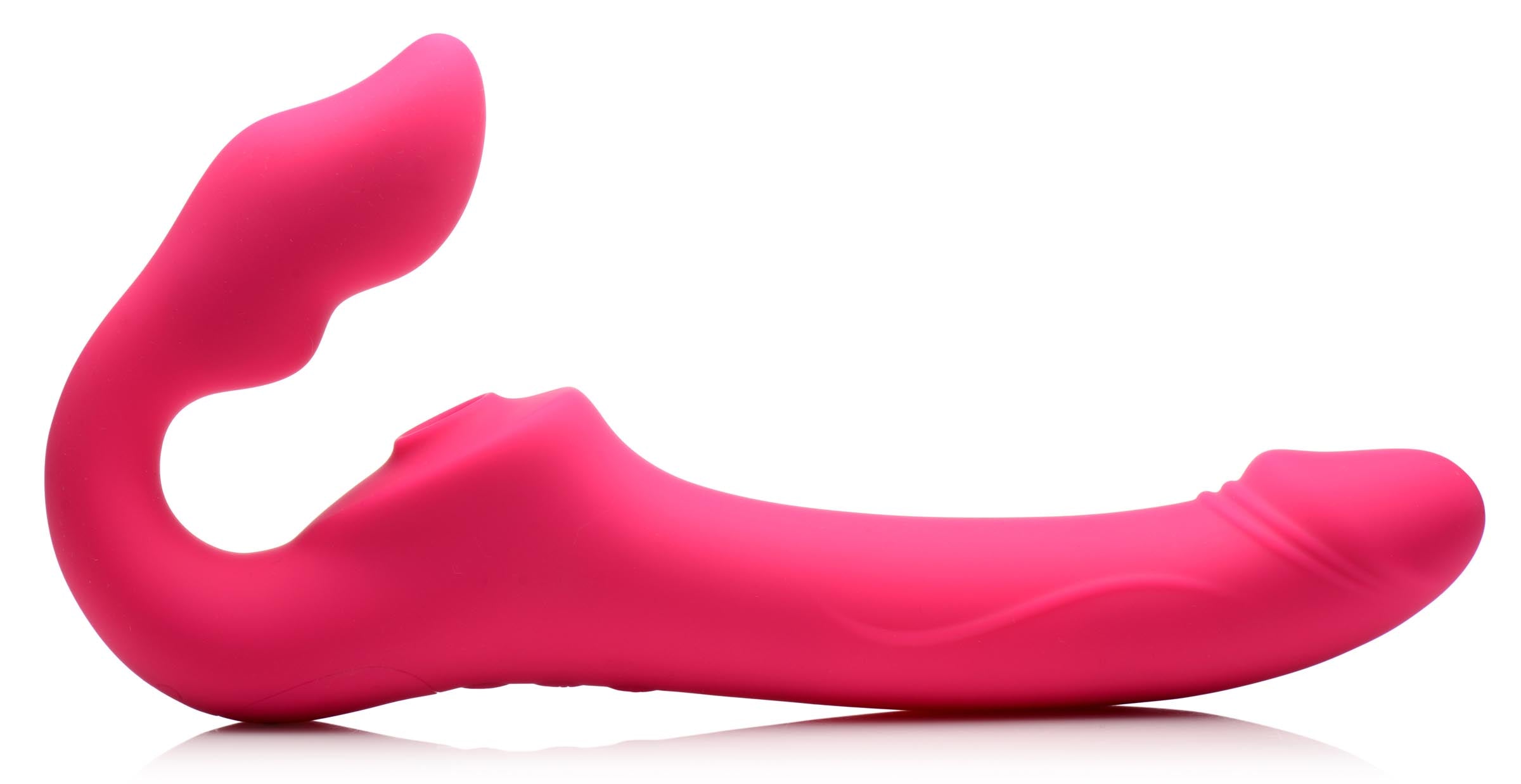 Pink strapless strap-on lying on a white background