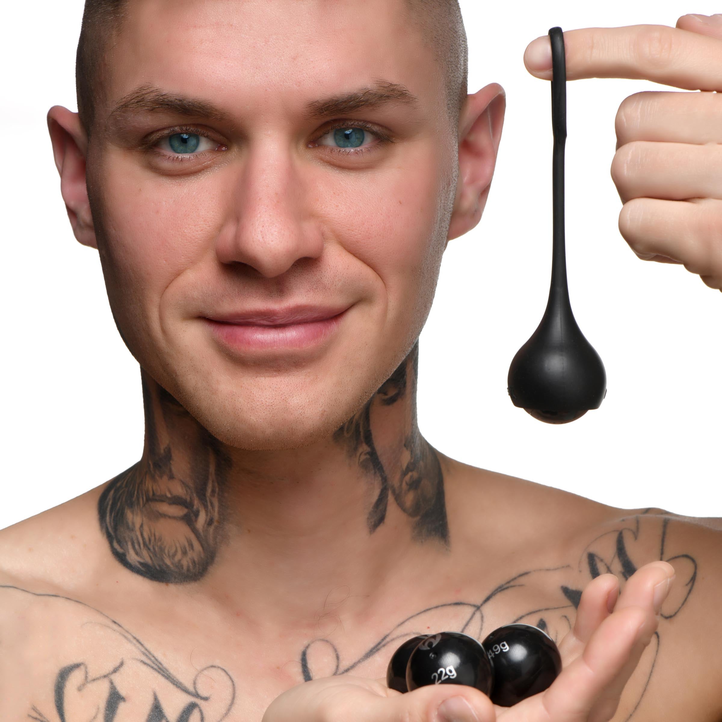 Tattooed individual showcasing the silicone penis strap with weights