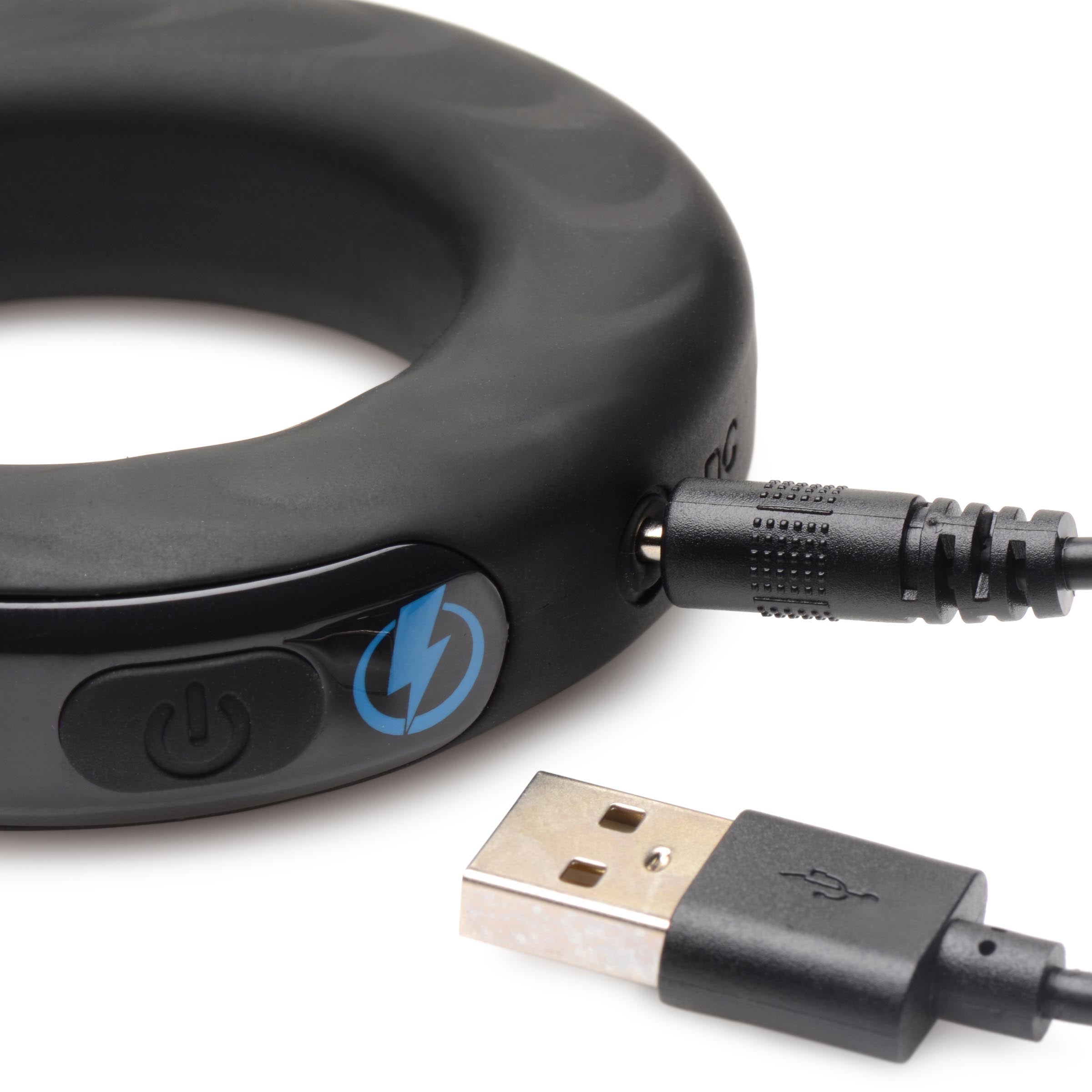 Black silicone E-stim Pro cock ring connected to a USB charging cable