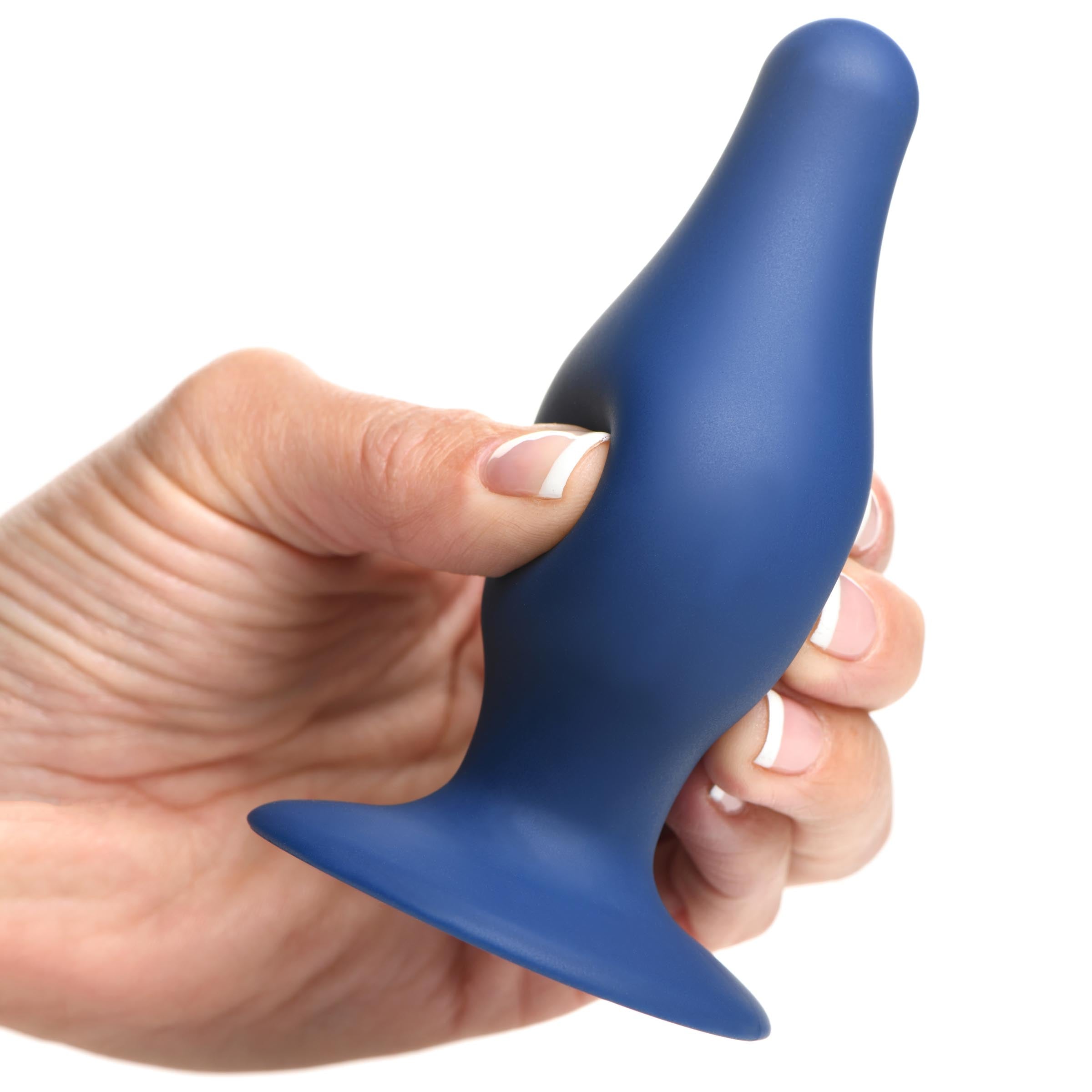 Close-up of a hand holding a blue squeezable tapered anal plug against a white background