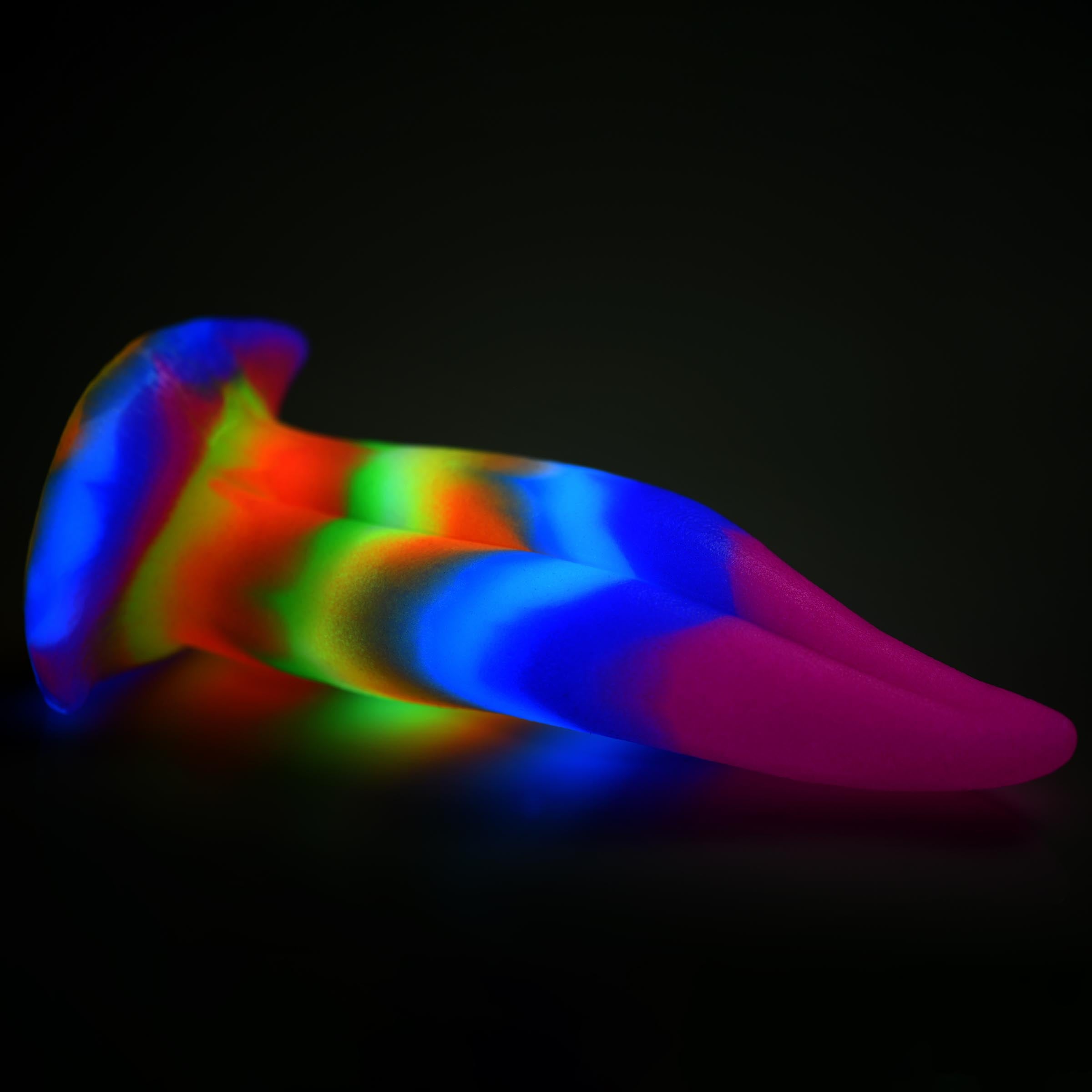 Glow-in-the-dark silicone dildo with unicorn-themed design on a black background