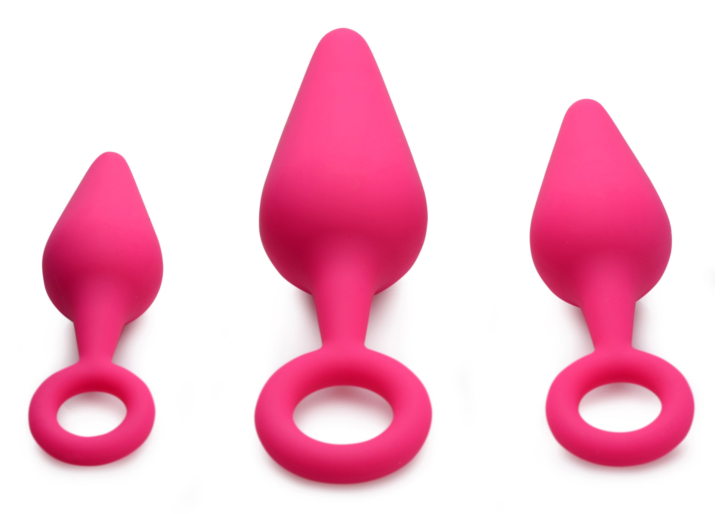 Set of three silicone anal plugs with ring handles, including a heart-shaped design, in pink