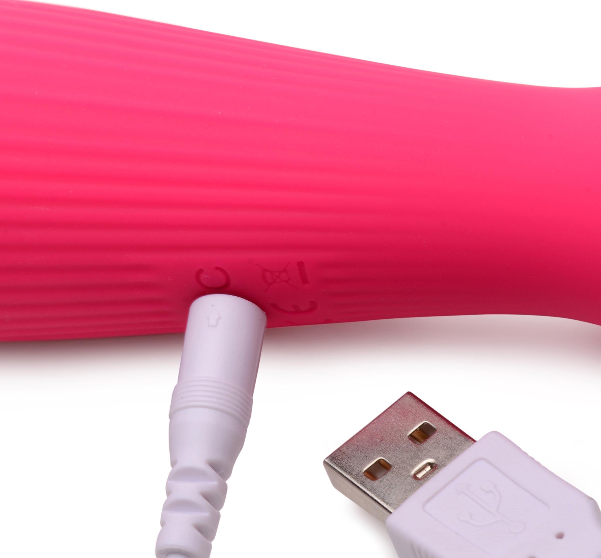 Pink wand massager being charged with a USB cable