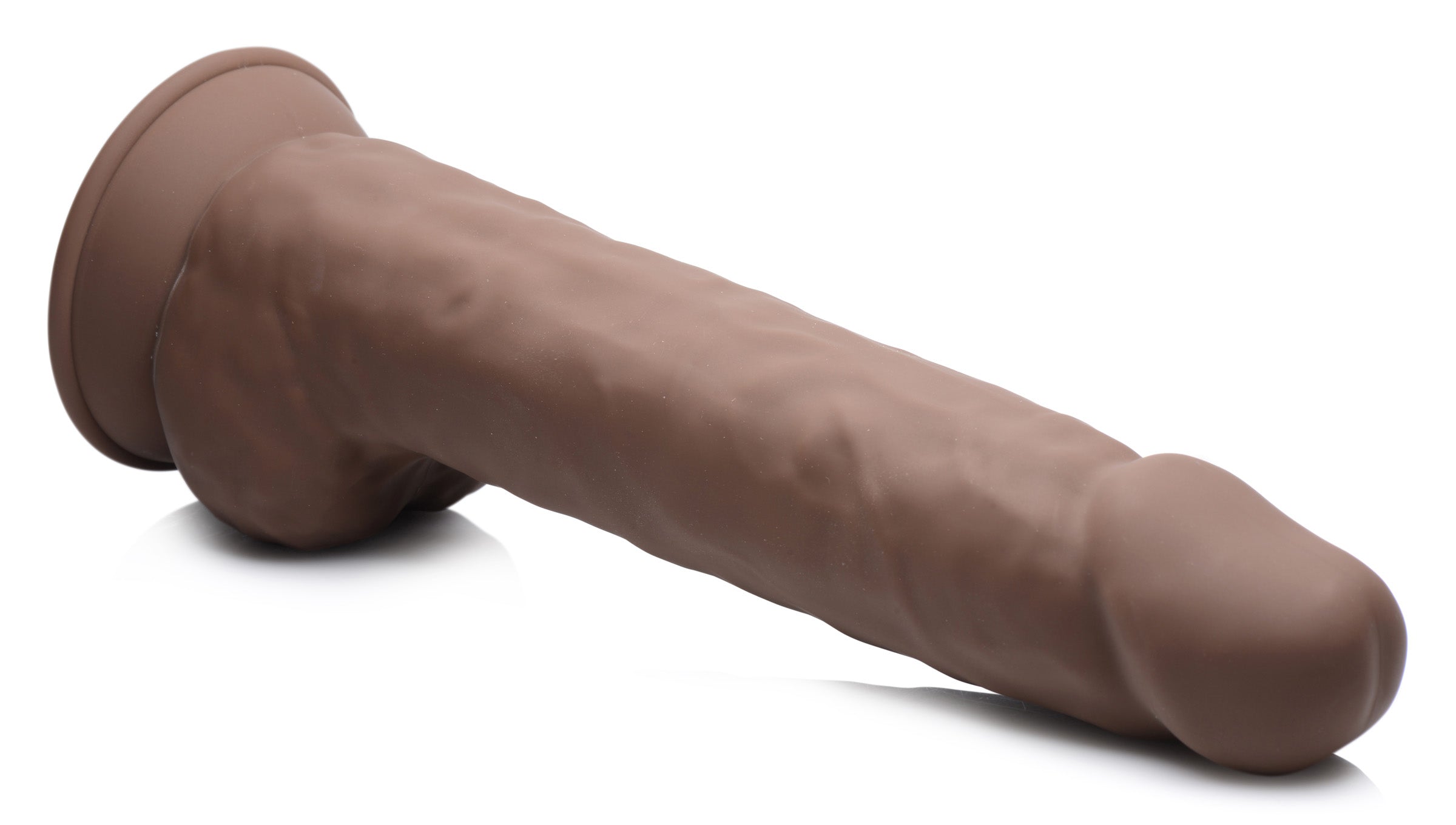 Dark silicone dildo with a lifelike shape and balls against a white background