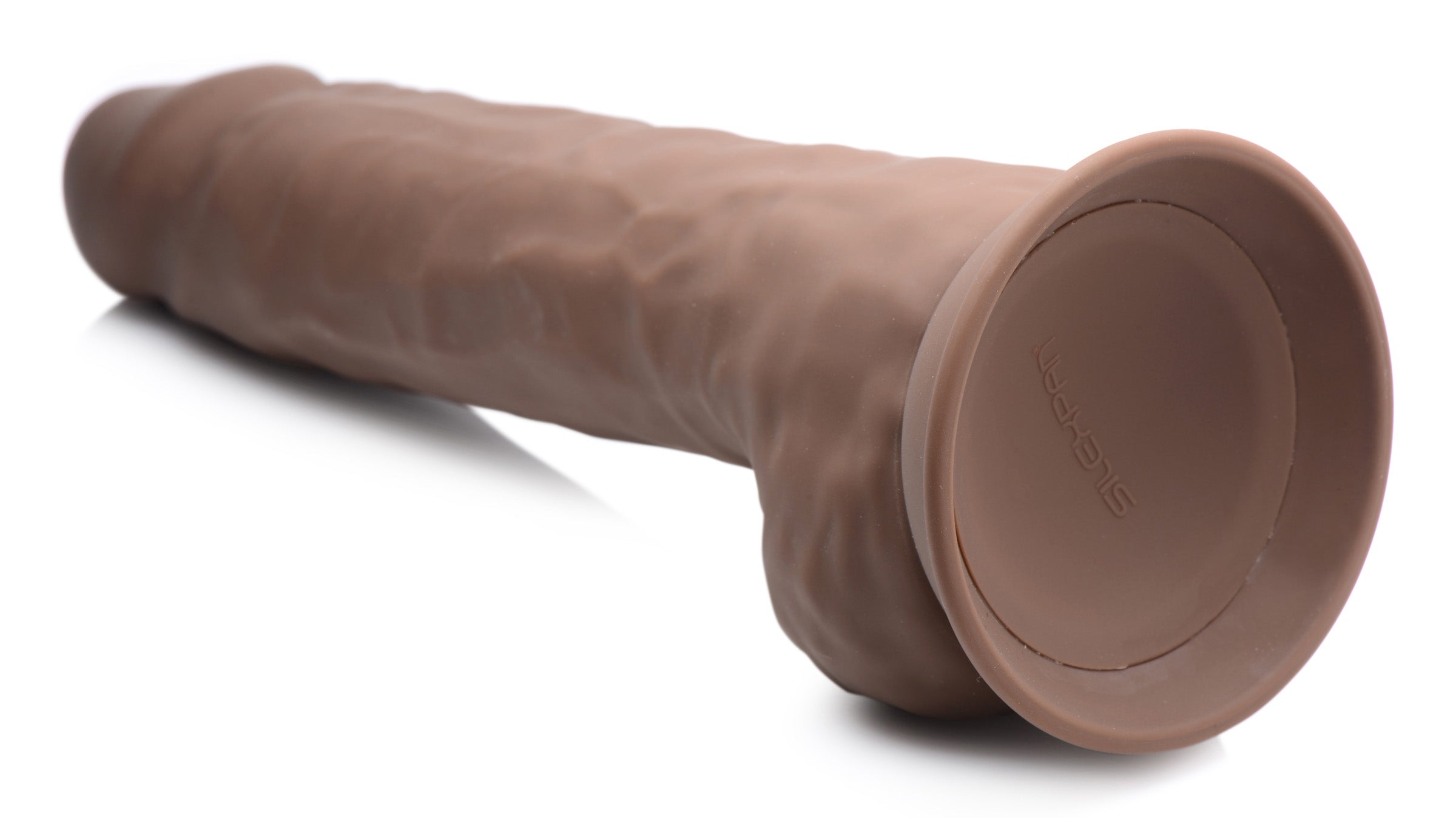 The Silexpan 10-inch silicone dildo with balls resting on a white surface