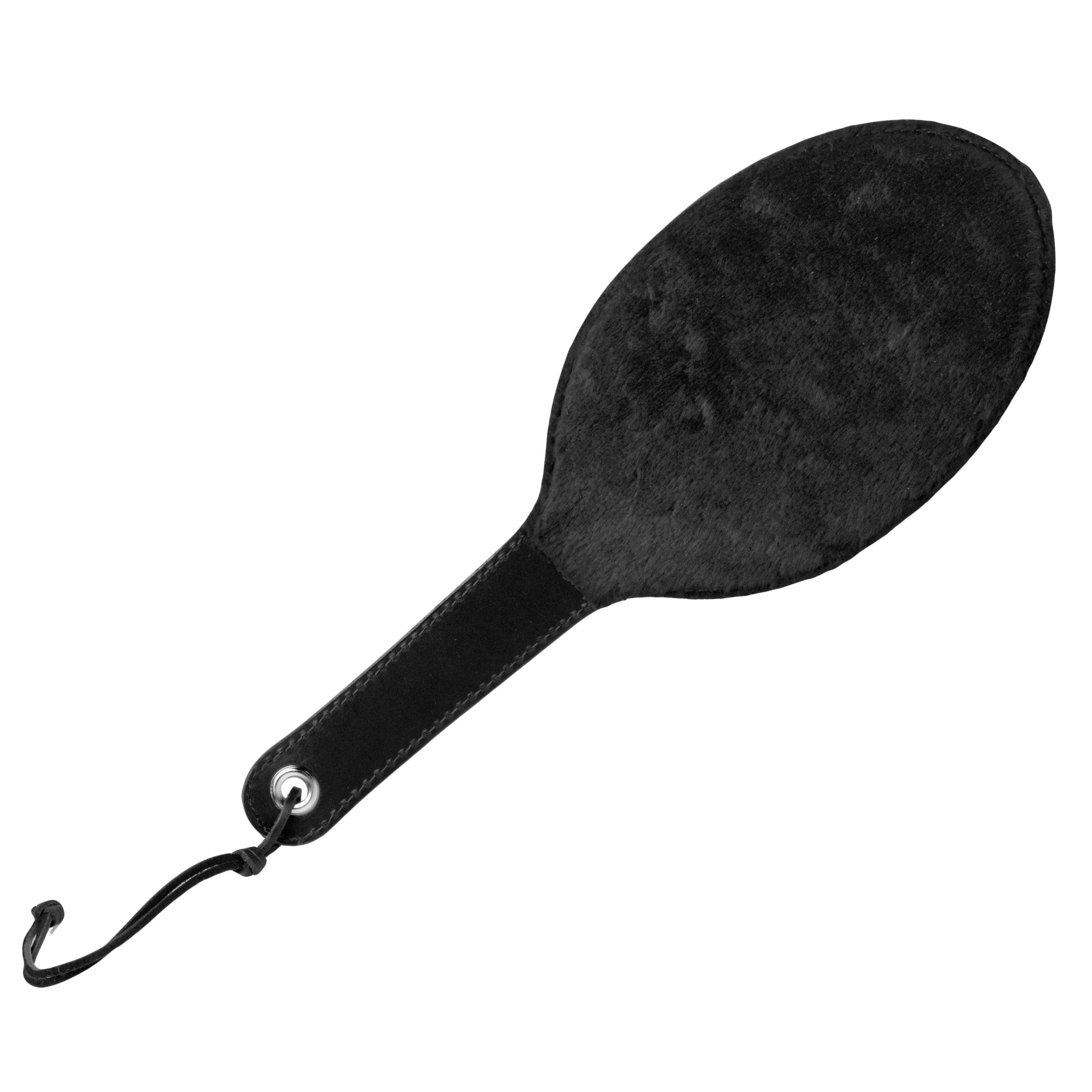 A round leather paddle with fur lining and a handle