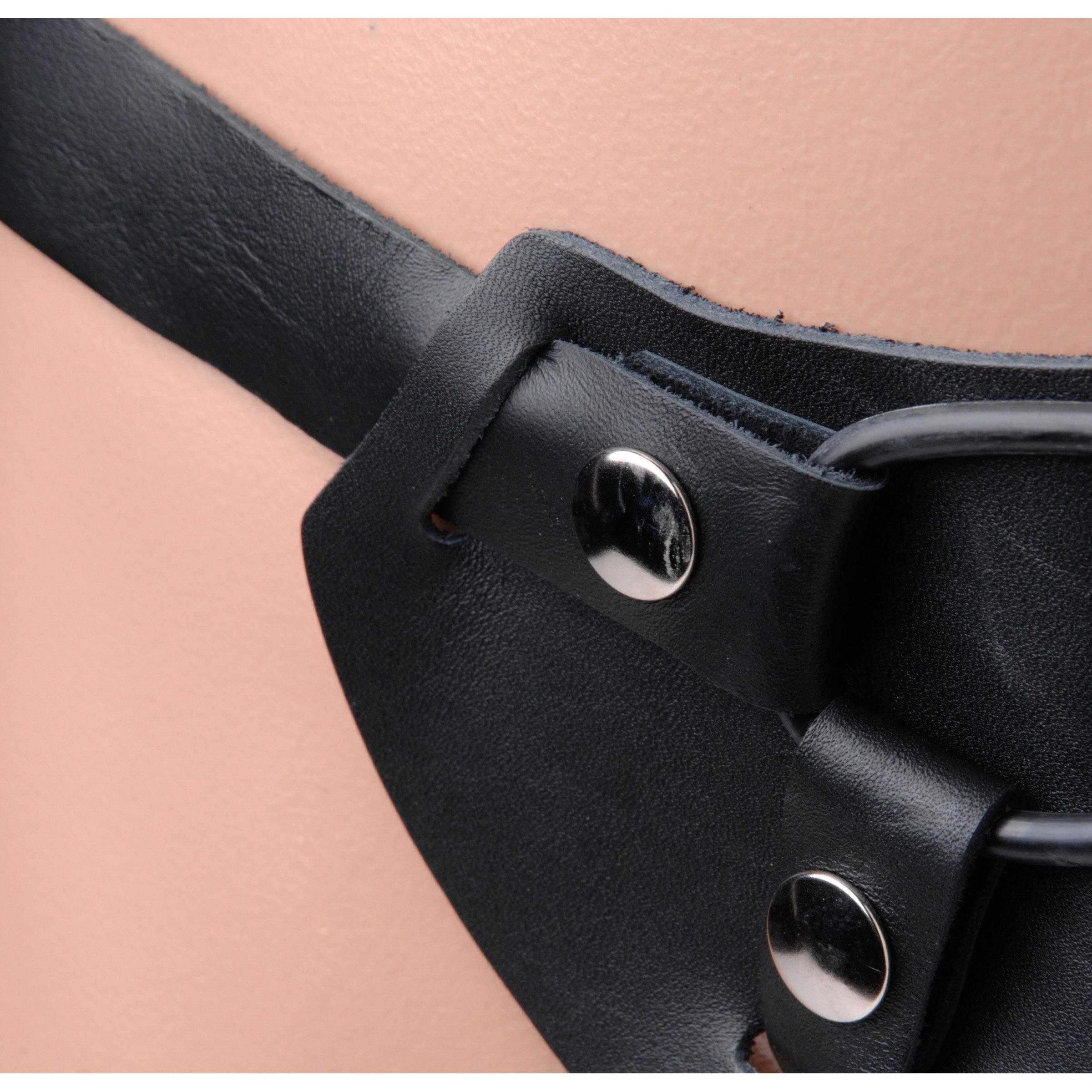 Detailed view of a black leather dildo harness with metal buckles