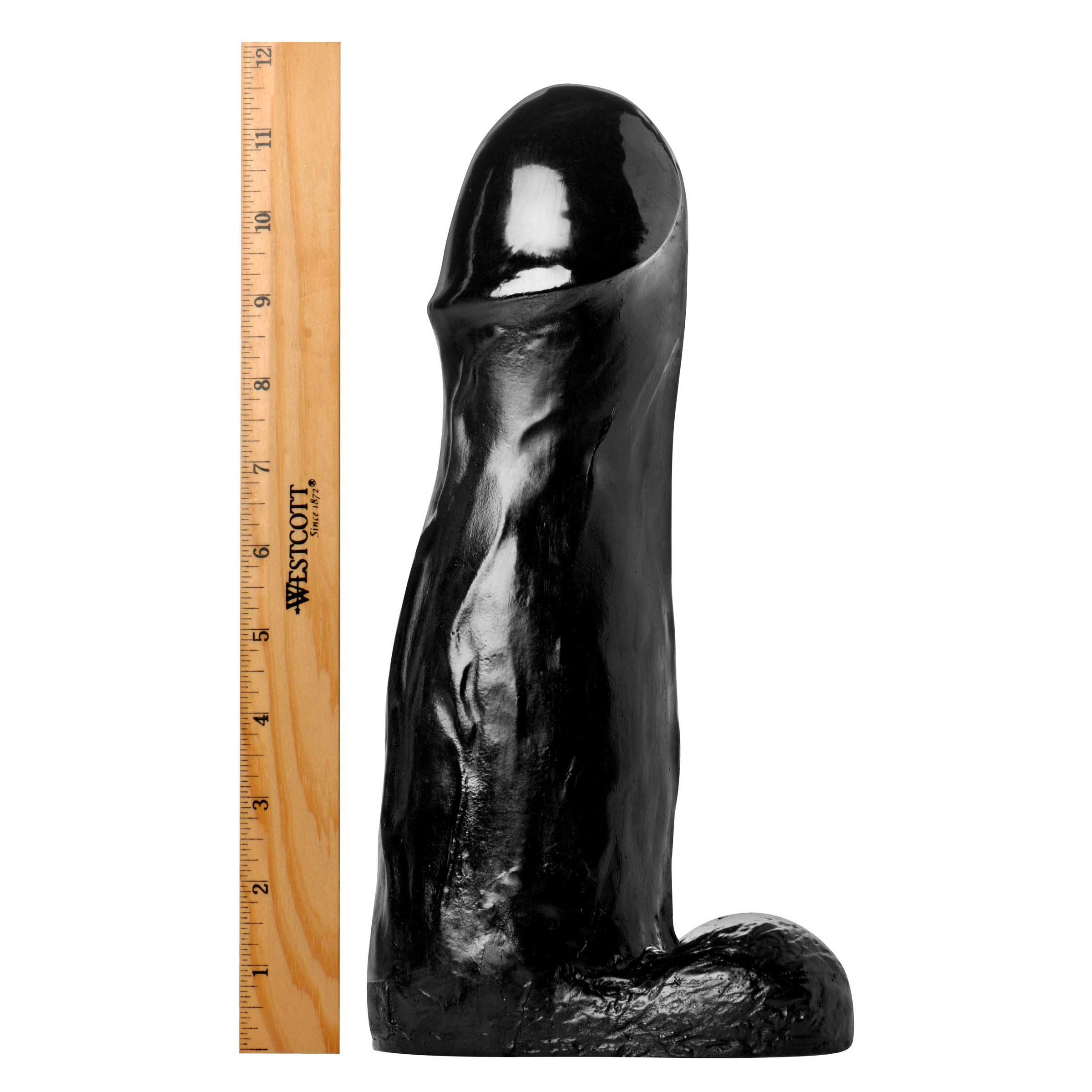 The Manolith black silicone dildo with a size comparison ruler